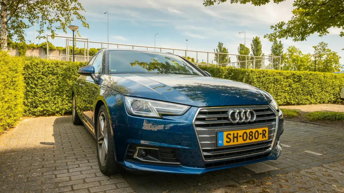 blue audi a 4 parked on gray brick pavement during daytime